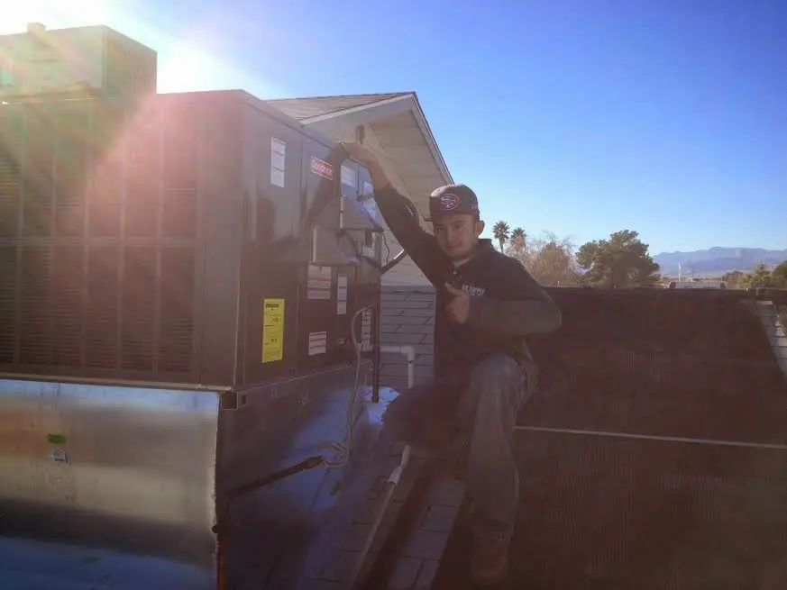 HVAC technician performing AC Tune-Up on a rooftop unit in Matthews